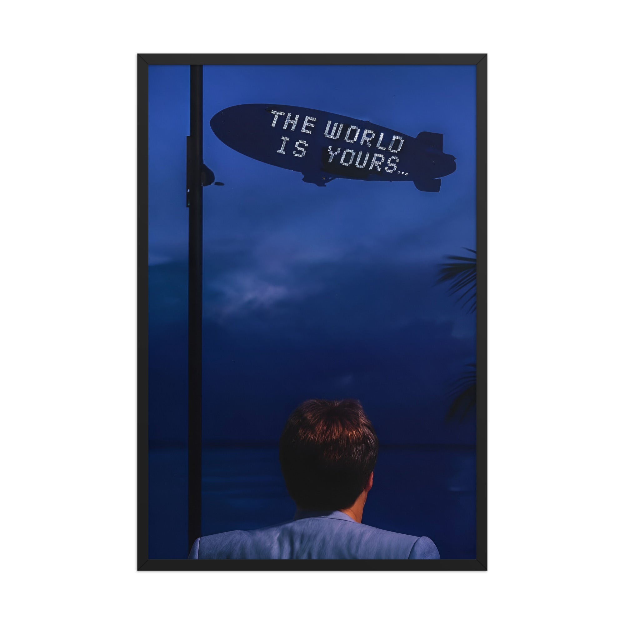 The World Is Yours framed wall art featuring a the iconic Scarface-inspired scene with a blimp overhead and bold cinematic mood.