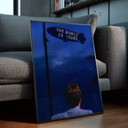 The World Is Yours framed wall art leaning against a gray sofa in a modern interior with wood floors, bookshelves, and contemporary decor
